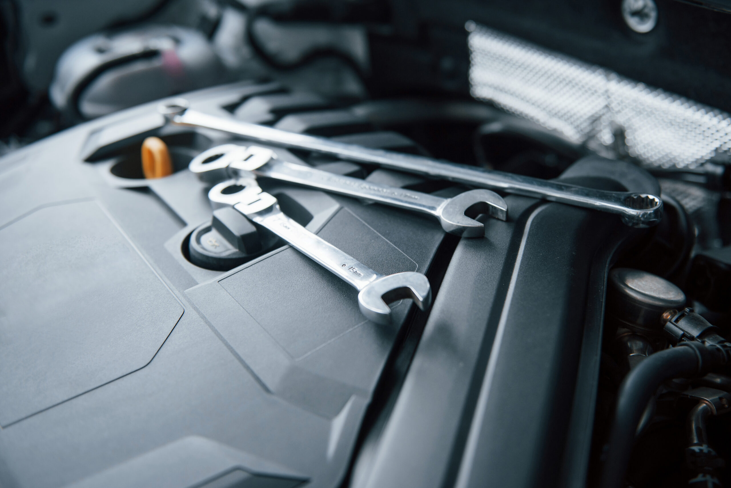 Repair tools lying down on the engine of automobile under the hood Repair tools lying down on the engine of automobile under the hood